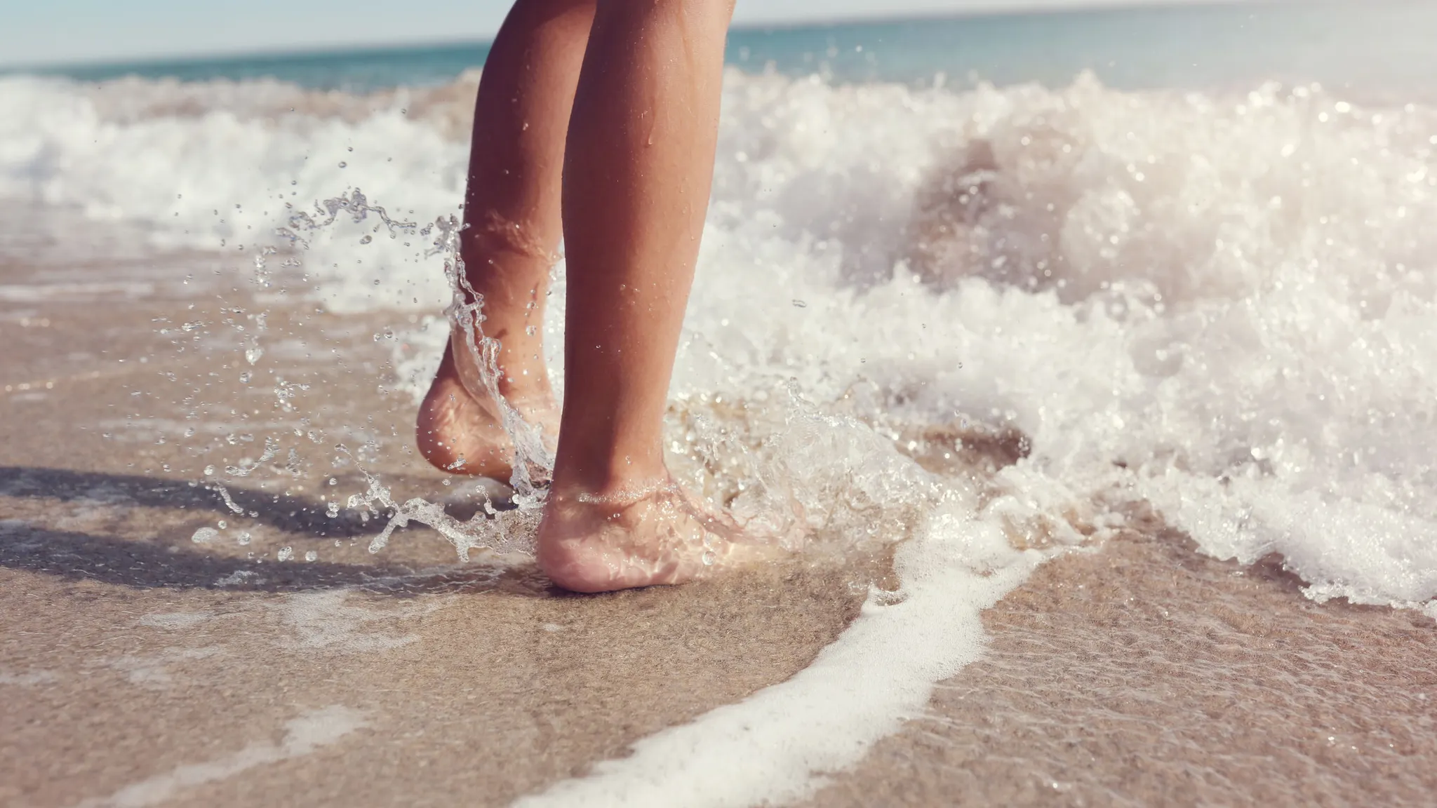 Voeten in de zee op het strand