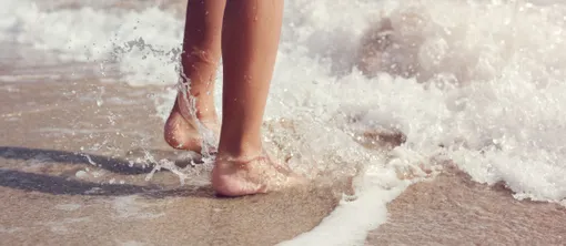 Voeten in de zee op het strand