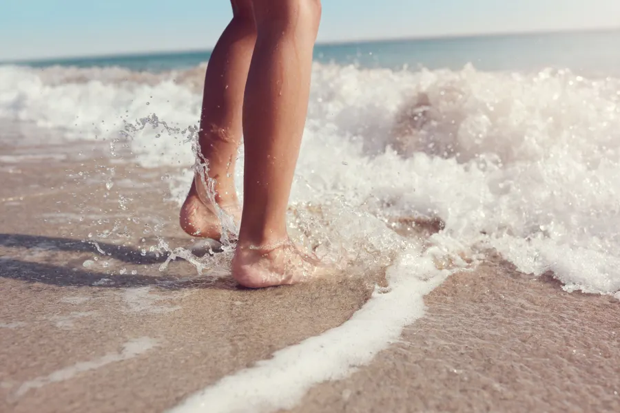 Voeten in de zee op het strand