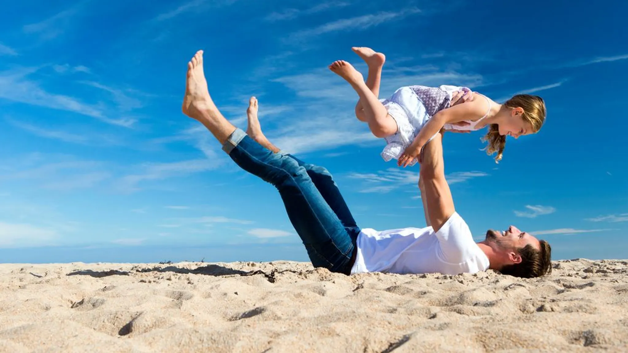 Vader met dochter spelend op het strand in de zomer