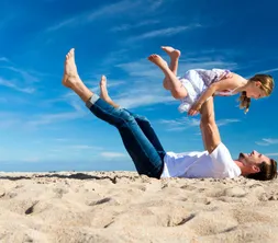 Vader met dochter spelend op het strand in de zomer