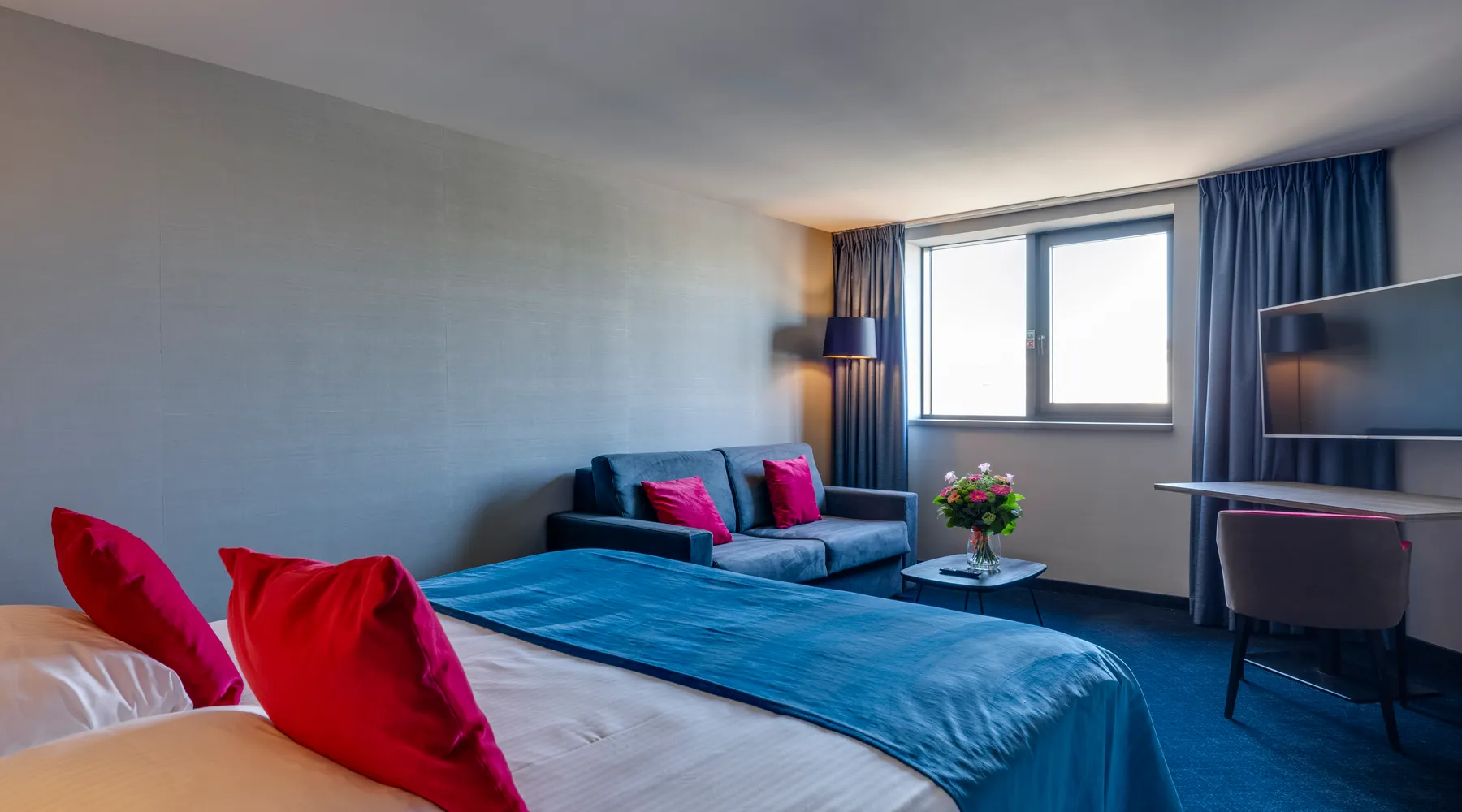 chambre d’hôtel spacieuse avec lit king size et coin salon à Liège