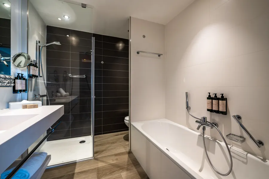 Salle de bain avec baignoire et douche de la chambre Classic King à Liège