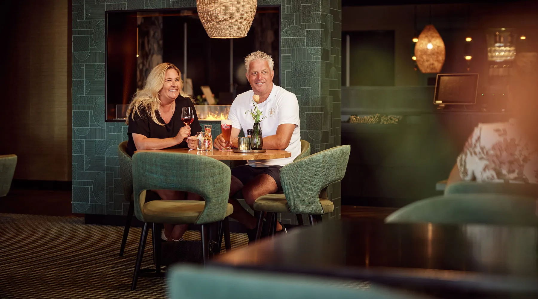 Relaxing on the terrace at Van der Valk Texel with drinks and a scenic view.