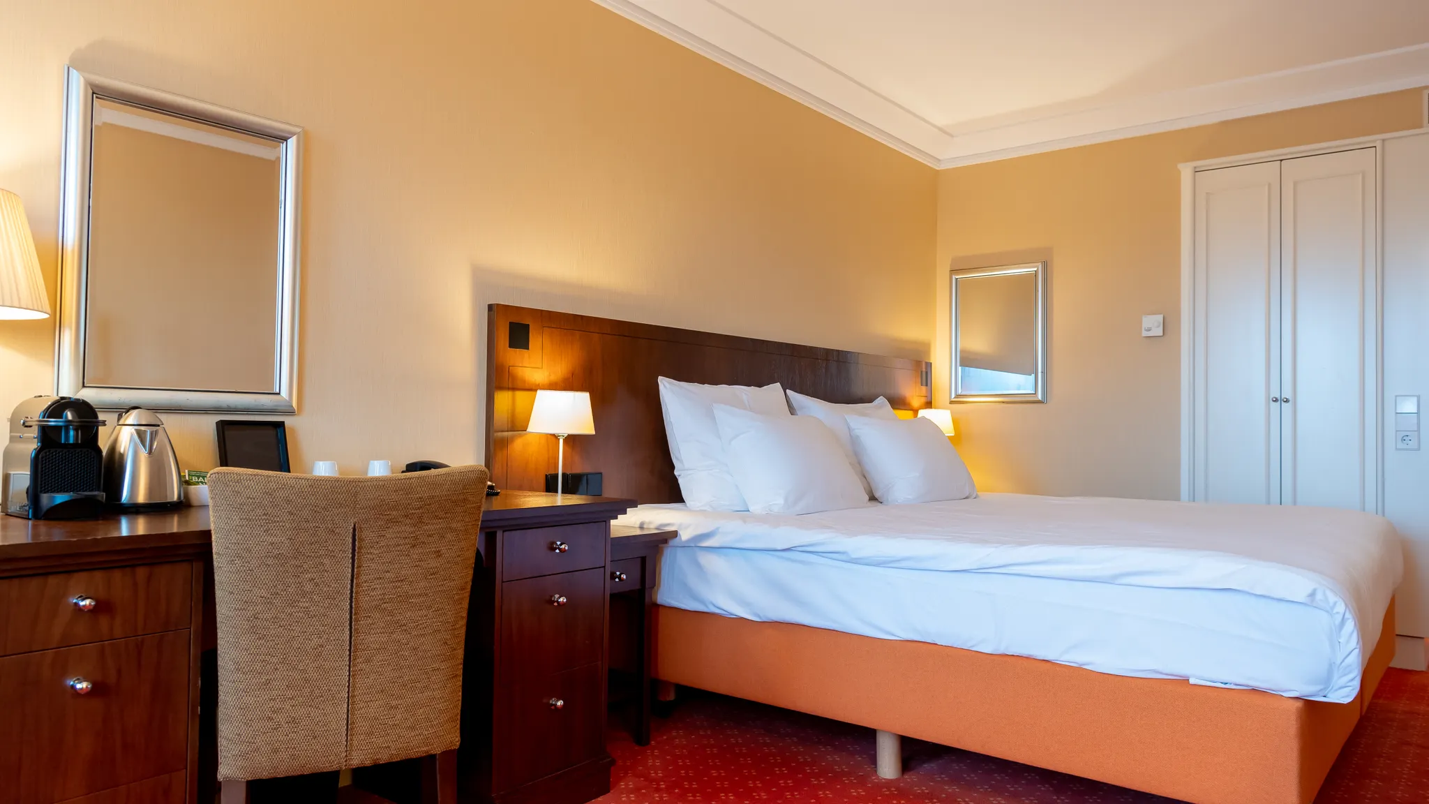 Schlafbereich und Schreibtisch in einem Standardzimmer mit Balkon