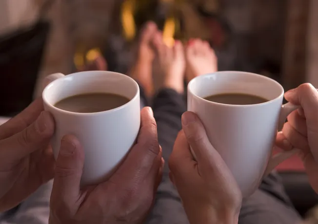 Boire une tasse de chocolat chaud près de la cheminée
