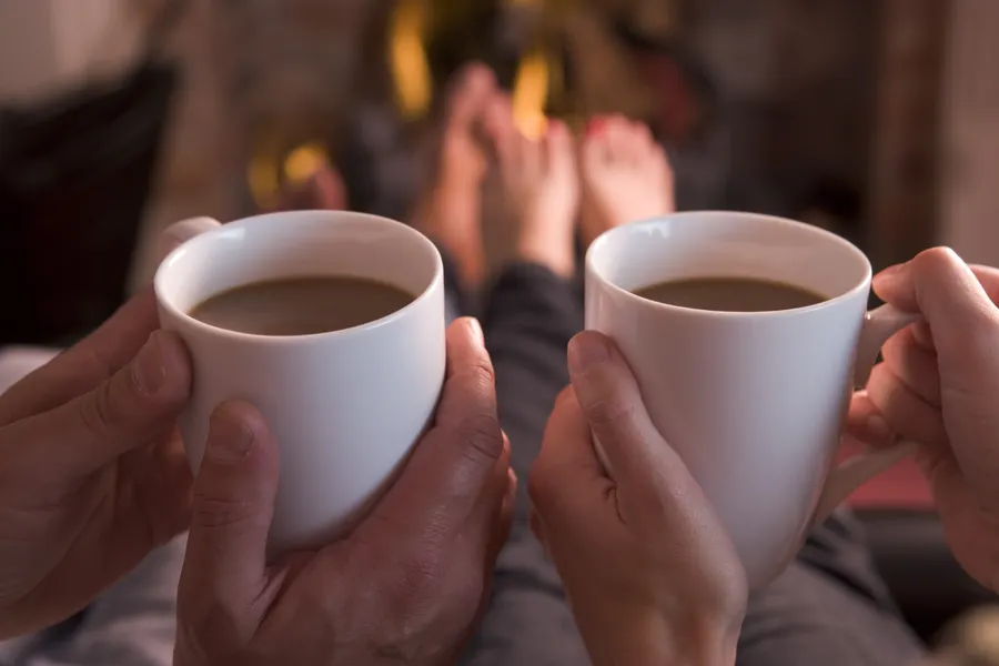 Kopje chocolademelk drinken bij het haardvuur