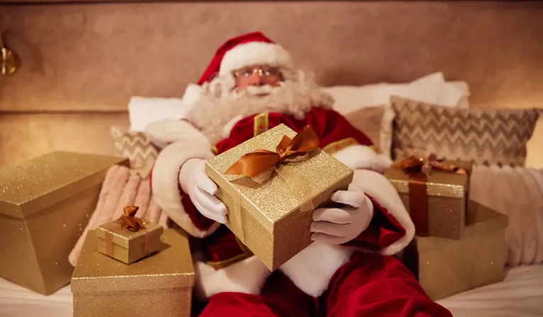 Santa Claus in bed at Van der Valk Hotel Gorinchem-A15 with lots of packages