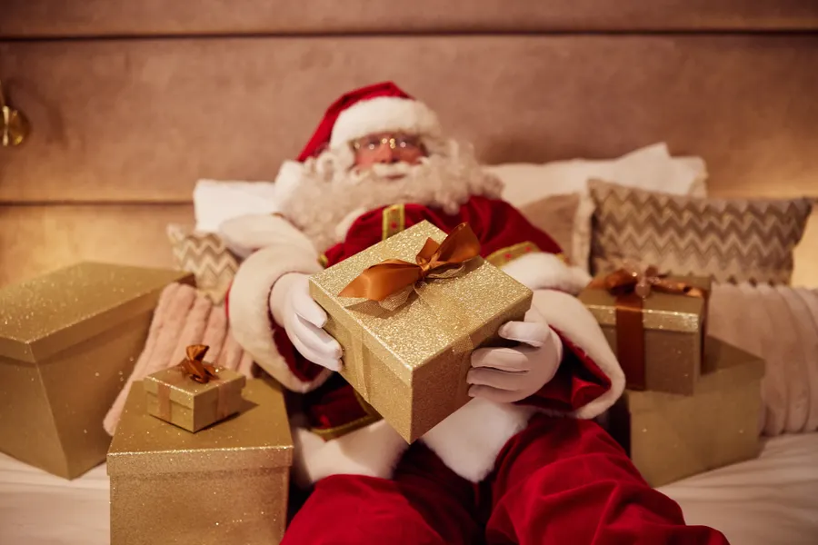 Kerstman op bed bij Van der Valk Hotel Gorinchem-A15 met allemaal pakketjes