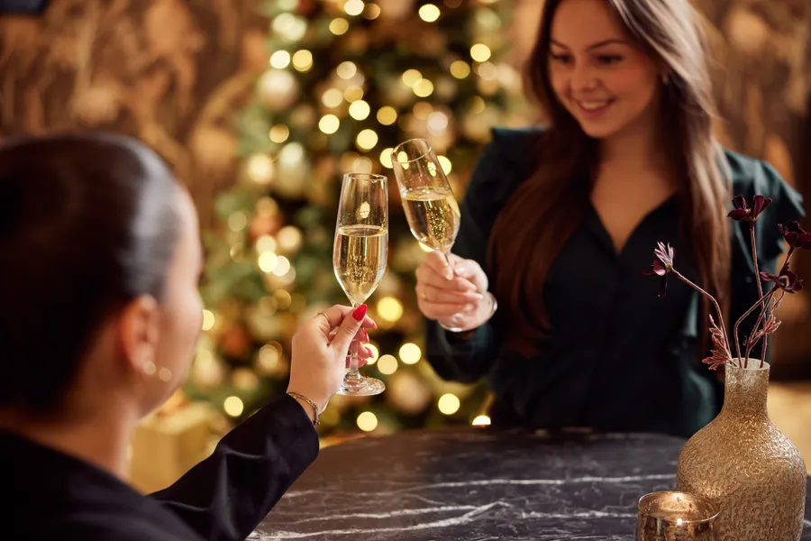 Deux dames trinquent au champagne.