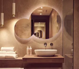 Lavabo avec miroirs ronds dans la salle de bains d'une chambre de l'hôtel Van der Valk à Gorinchem-A15