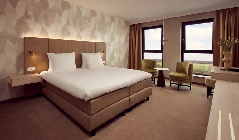 Chambre d'hôtel moderne et confortable avec lit double et coin salon à l'hôtel Van der Valk Gorinchem-A15