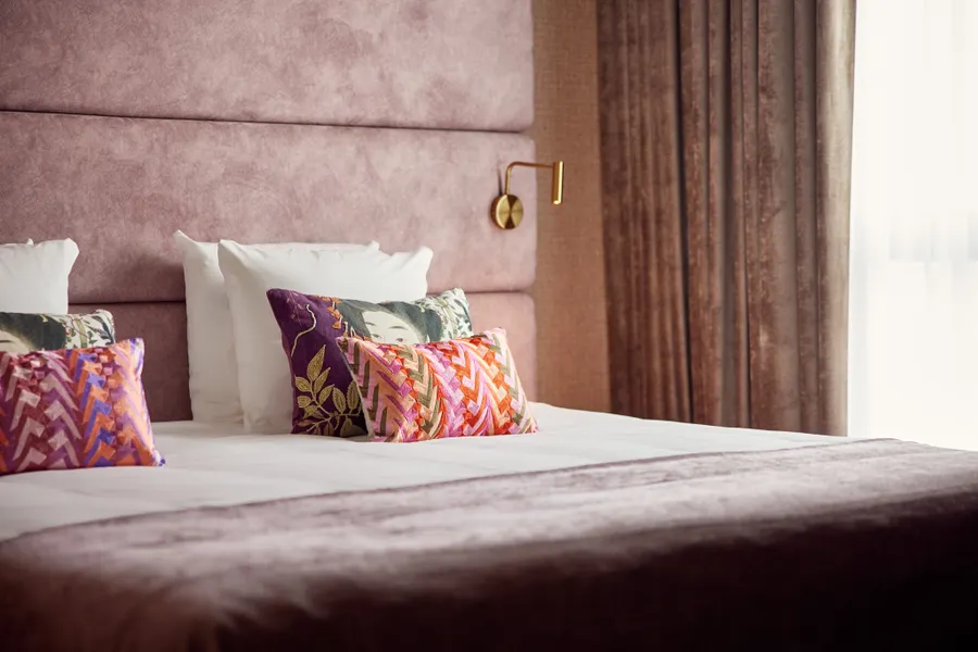 Kleurrijke kussens op een comfortabel tweepersoonsbed in de Family Suite van Van der Valk Hotel Gorinchem-A15