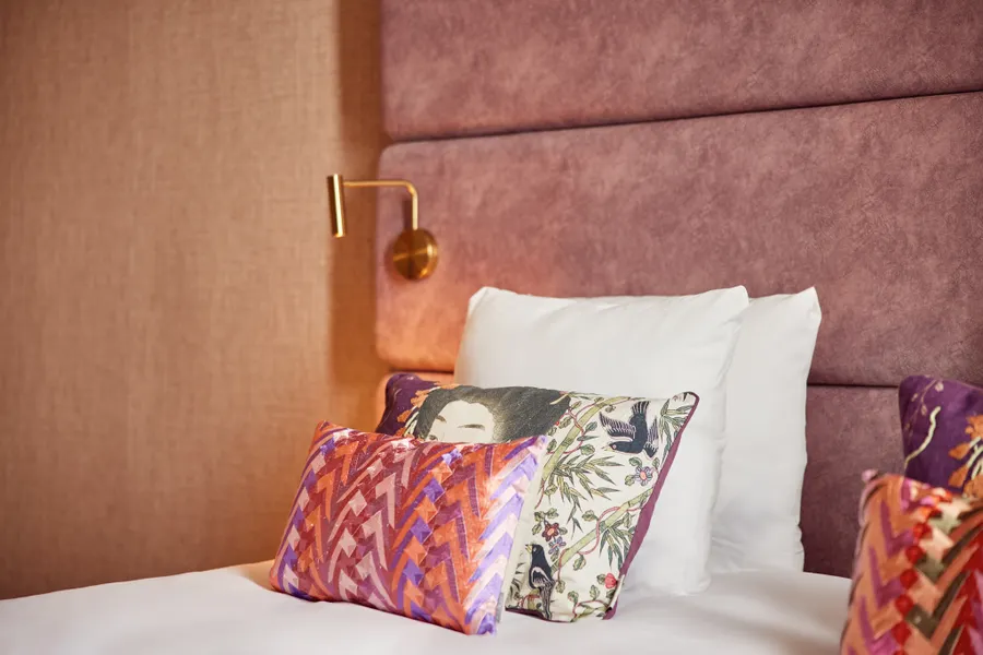 Sfeervol opgemaakt bed met kleurrijke kussens in de Family Suite van Van der Valk Hotel Gorinchem-A15