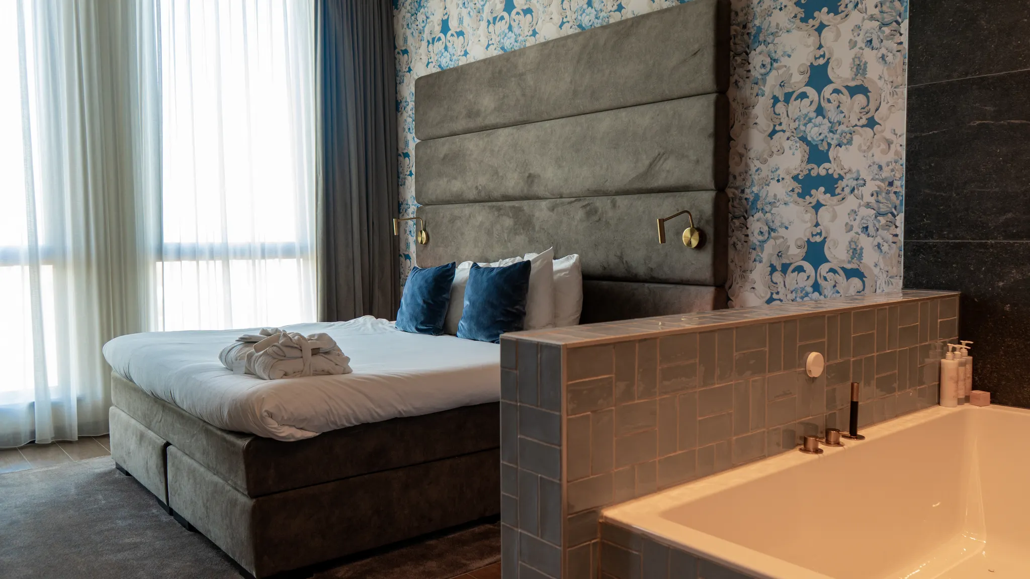 Lit double avec baignoire balnéo dans l'élégante suite spa de l'hôtel Van der Valk à Gorinchem-A15