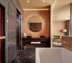 Salle de bains spacieuse avec cabine infrarouge, baignoire balnéo et douche à effet pluie à l'hôtel Van der Valk Gorinchem-A15