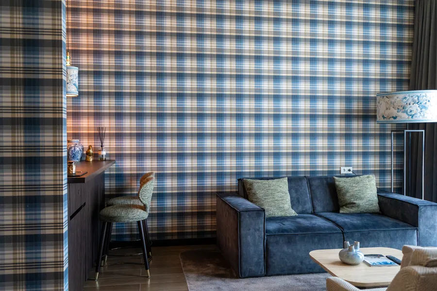 Sfeervol ingerichte zithoek met geruit behang bij Van der Valk Hotel Gorinchem-A15