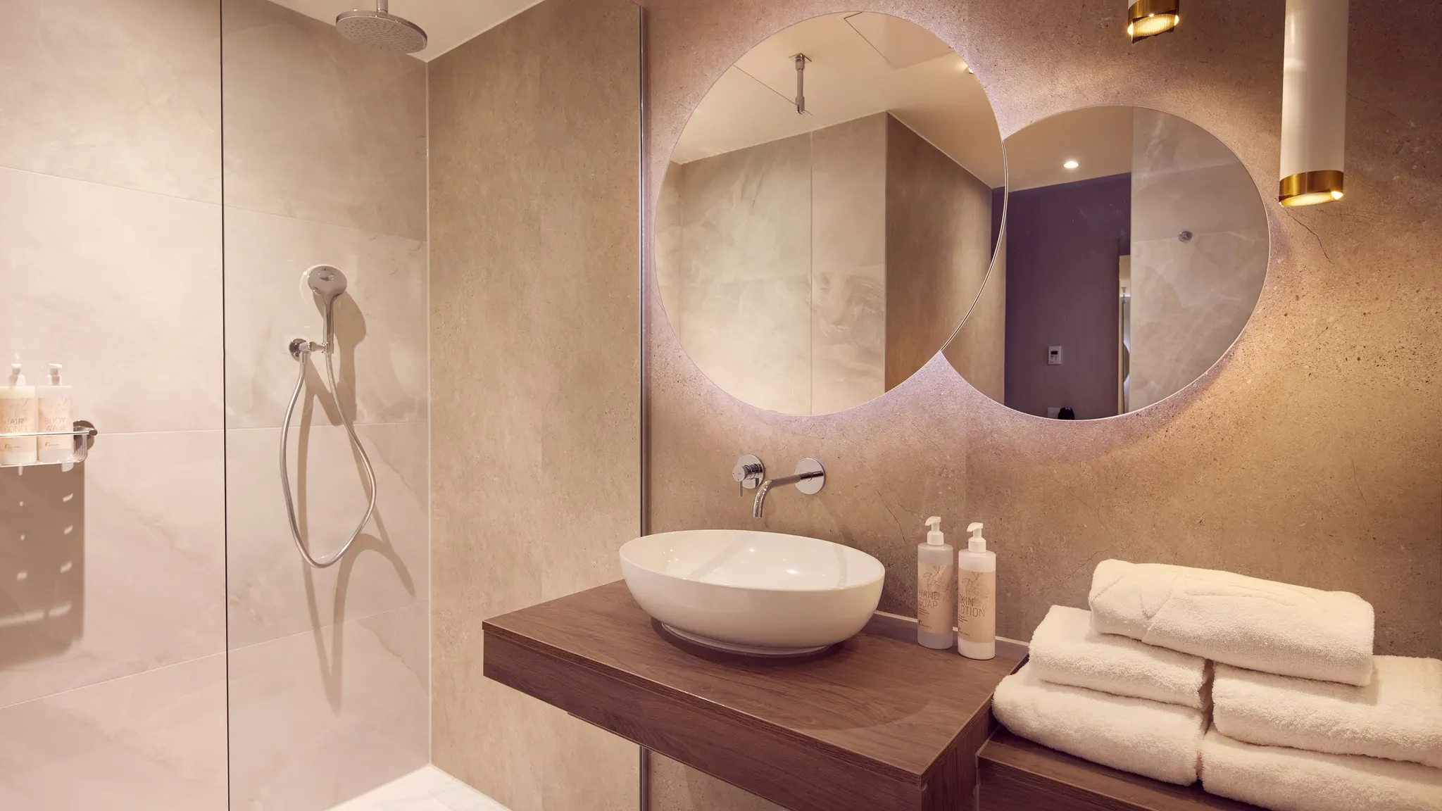 Moderne badkamer met regendouche, wastafel en ronde spiegels in Van der Valk Hotel Gorinchem-A15