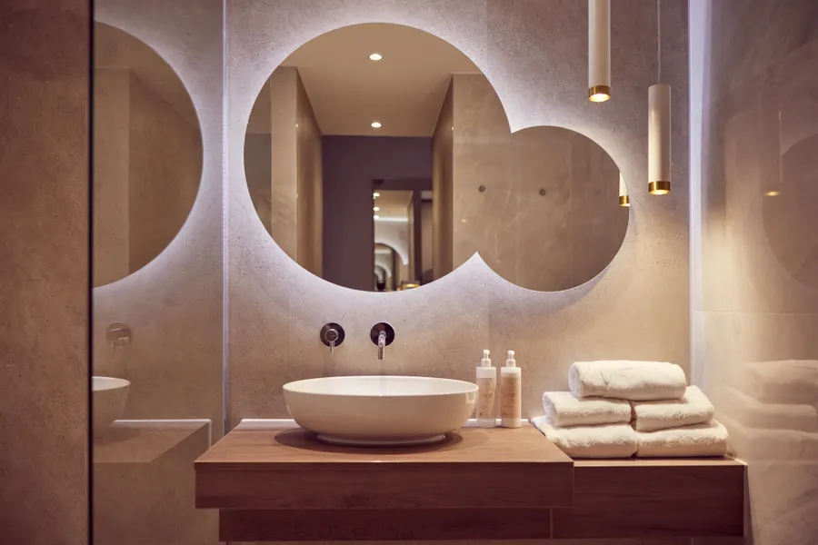 Moderne badkamer met wastafel en ronde spiegels in Van der Valk Hotel Gorinchem-A15
