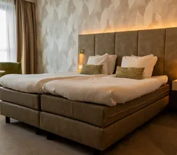 Twin bedden met comfortabel zithoekje in een moderne hotelkamer van Van der Valk Hotel Gorinchem-A15