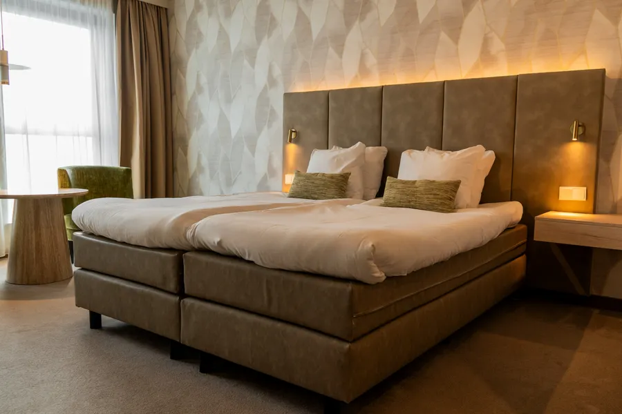 Twin bedden met comfortabel zithoekje in een moderne hotelkamer van Van der Valk Hotel Gorinchem-A15