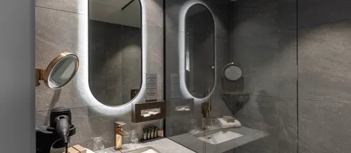 Salle de bain avec douche à l’italienne dans la chambre Deluxe de l’hôtel Van der Valk Waterloo