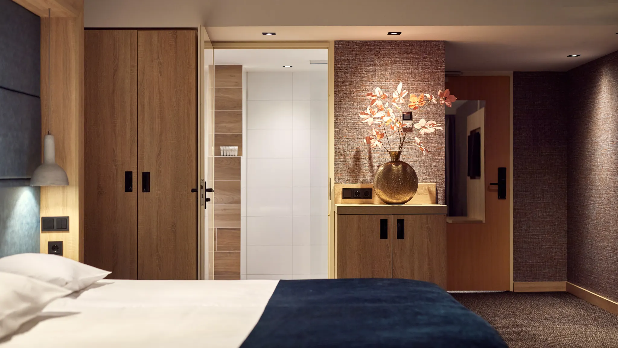Modernes Komfort-Hotelzimmer mit offenem Kleiderschrank, stimmungsvoller Beleuchtung und stilvollem Interieur