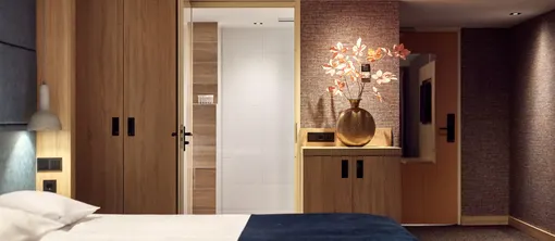 Modernes Komfort-Hotelzimmer mit offenem Kleiderschrank, stimmungsvoller Beleuchtung und stilvollem Interieur