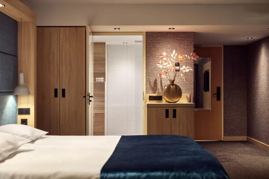 Moderne comfort hotelkamer met open kledingkast, sfeervolle verlichting en stijlvol interieur