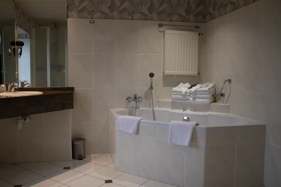Salle de bains luxueuse avec baignoire, lavabo spacieux et douche à l'italienne dans la pièce familiale.