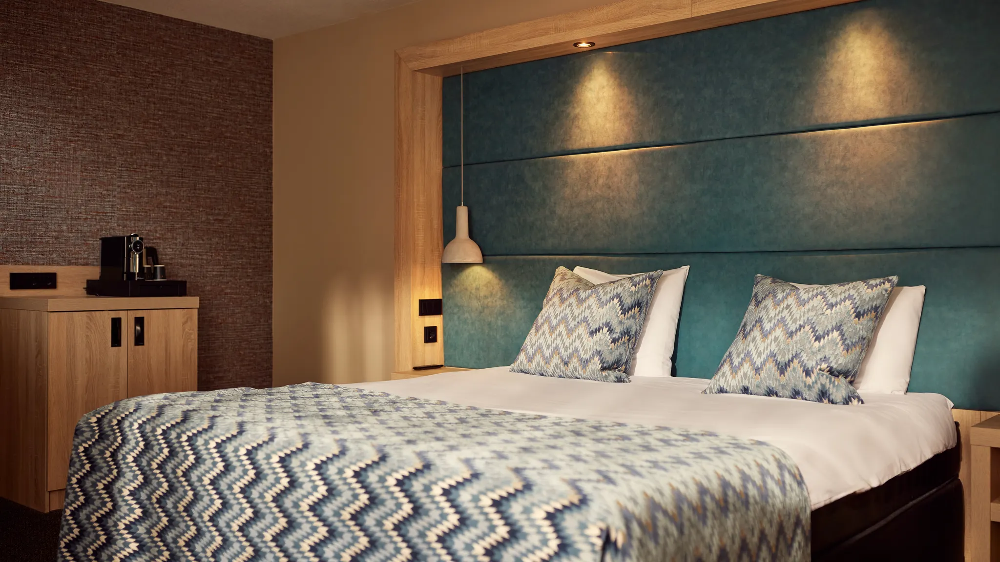 Komfortables Doppelbett mit luxuriösem Kopfteil im Superior Deluxe Hotelzimmer