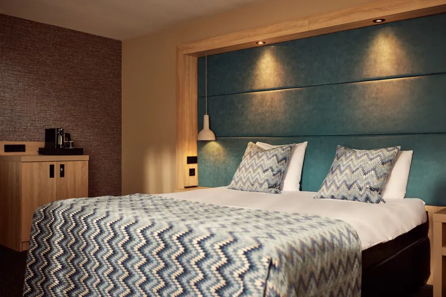 Comfortabel tweepersoonsbed met luxe hoofdbord in de Superior Deluxe hotelkamer
