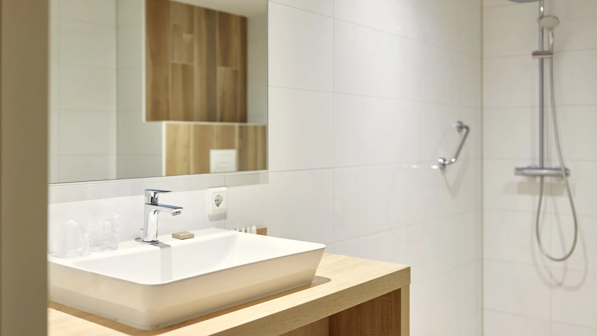 Modernes Badezimmer mit Doppelwaschbecken und geräumiger, ebenerdiger Dusche im Superior Deluxe Hotelzimmer