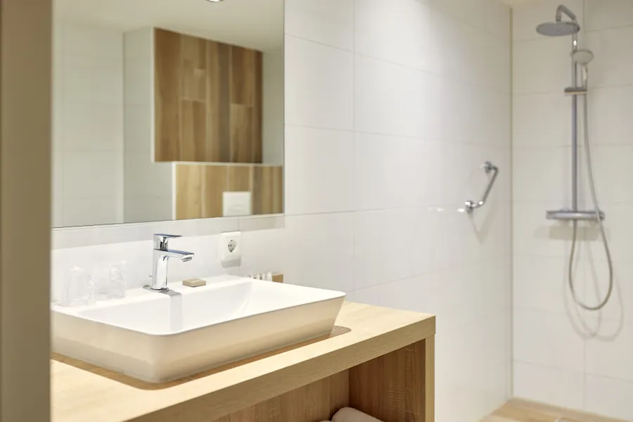 Moderne badkamer met dubbele wastafel en ruime inloopdouche in de Superior Deluxe hotelkamer