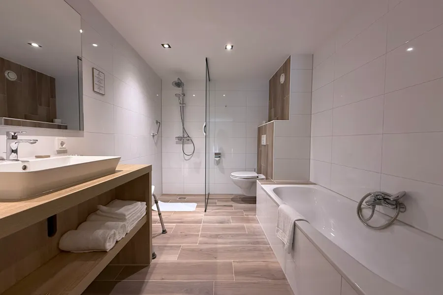 Salle de bain de luxe avec baignoire, douche à l'italienne et double lavabo à l'hôtel Van der Valk Leusden-Amersfoort