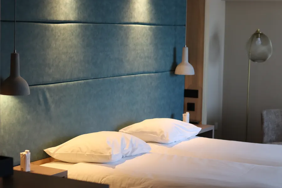Lit double confortable avec éclairage d'ambiance dans une chambre d'hôtel moderne du Van der Valk Hotel Leusden-Amersfoort