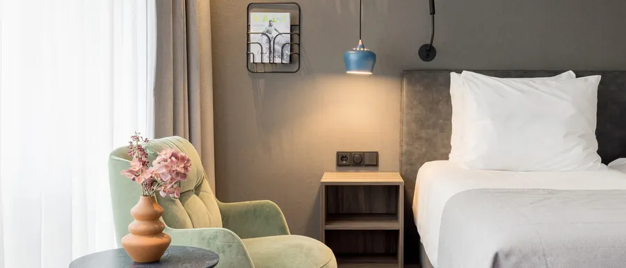 Stilvolle Sitzecke und Nachttisch im Superior Twin Room mit modernem Interieur.