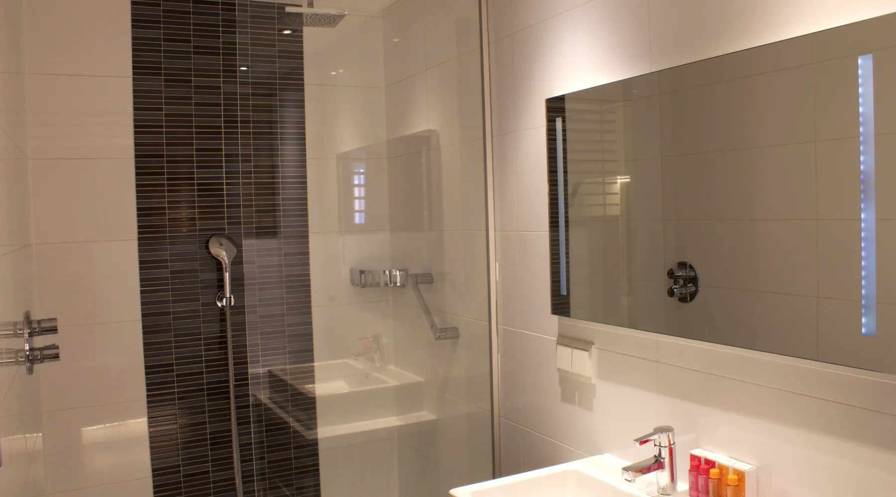 Badkamer met bad en douche