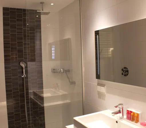 Badkamer met bad en douche