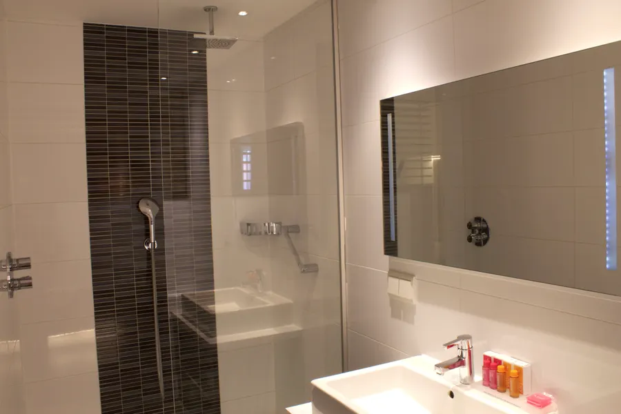 Badkamer met bad en douche