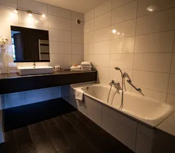 Badkamer met bad en douche