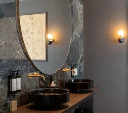 Badezimmer Marron Suite Van der Valk Nuland mit Doppelwaschbecken und Marmorausstattung.