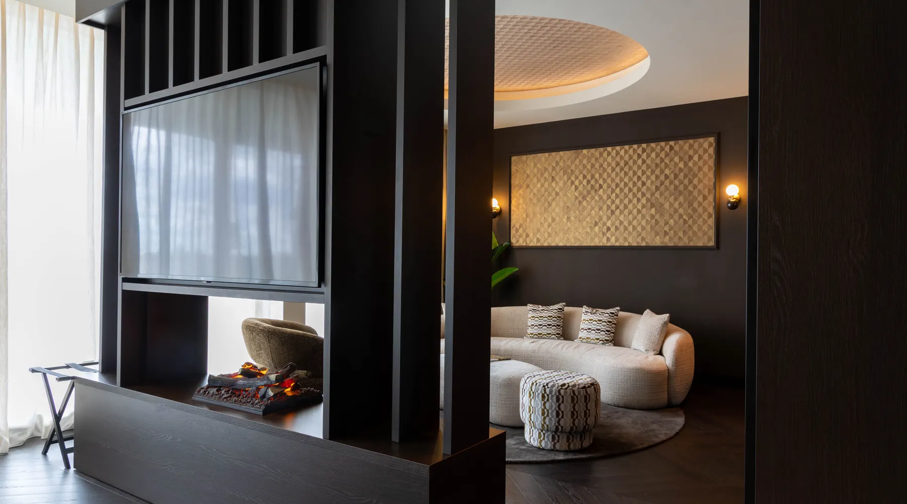 Marron Suite Van der Valk Nuland seating area with round sofa and fireplace.