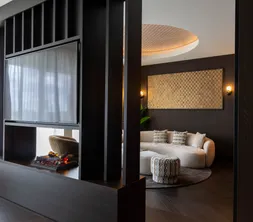 Marron Suite Van der Valk Nuland Sitzecke mit runder Couch und Kamin.