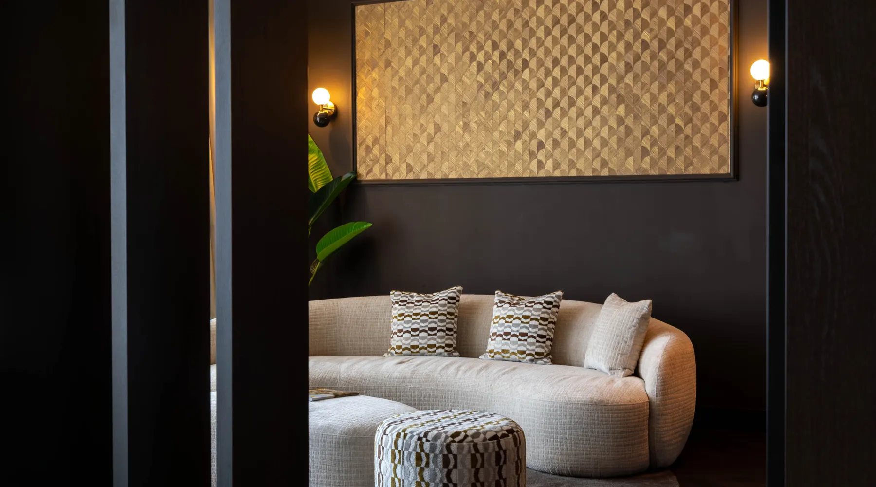 Marron Suite Van der Valk Nuland sitting area with round sofa and pouf.