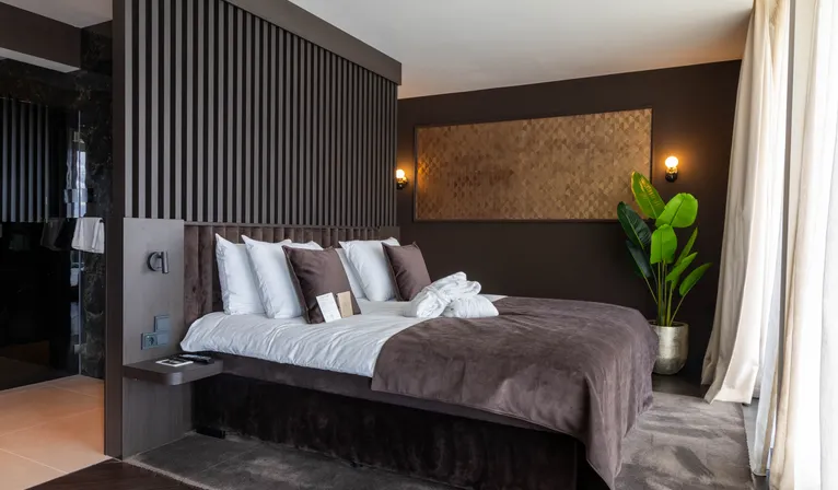 Marron Suite Van der Valk Nuland mit Kingsize-Bett und stilvollem Design.