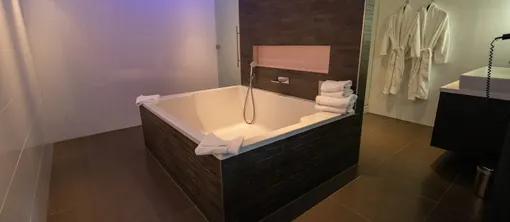 Badkamer met bad en douche