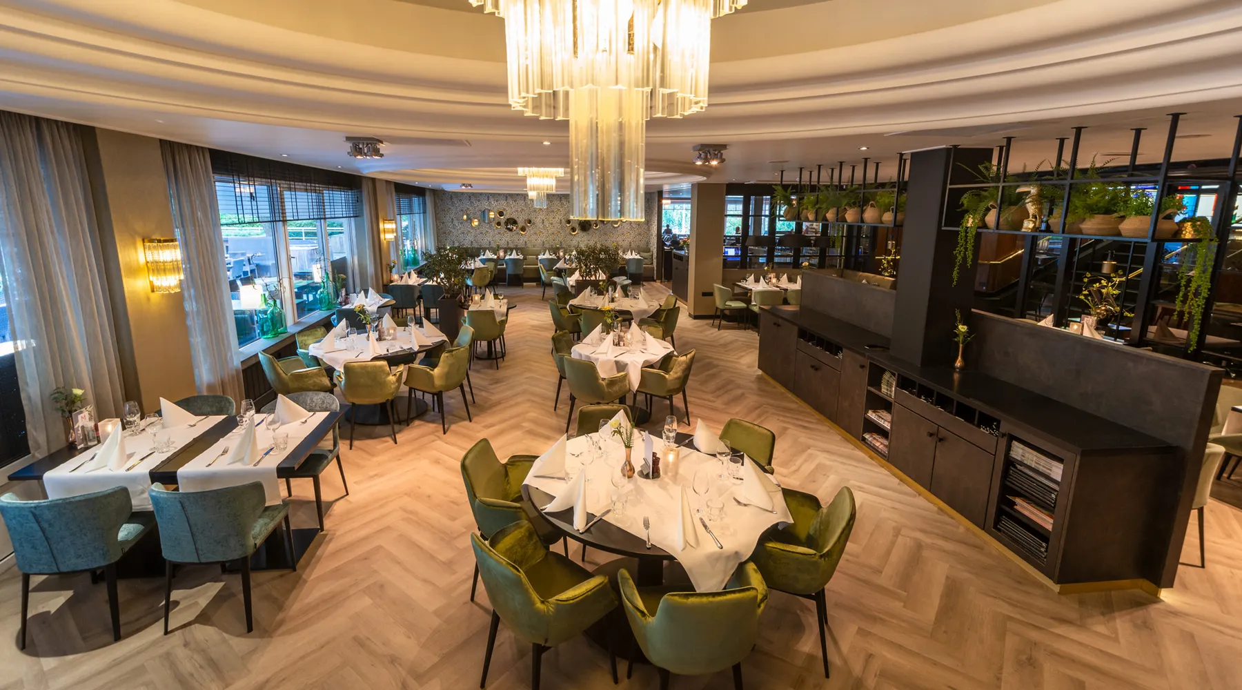 Overzicht van het restaurant, volledig in kerstsfeer gebracht met chique gedekte tafels.