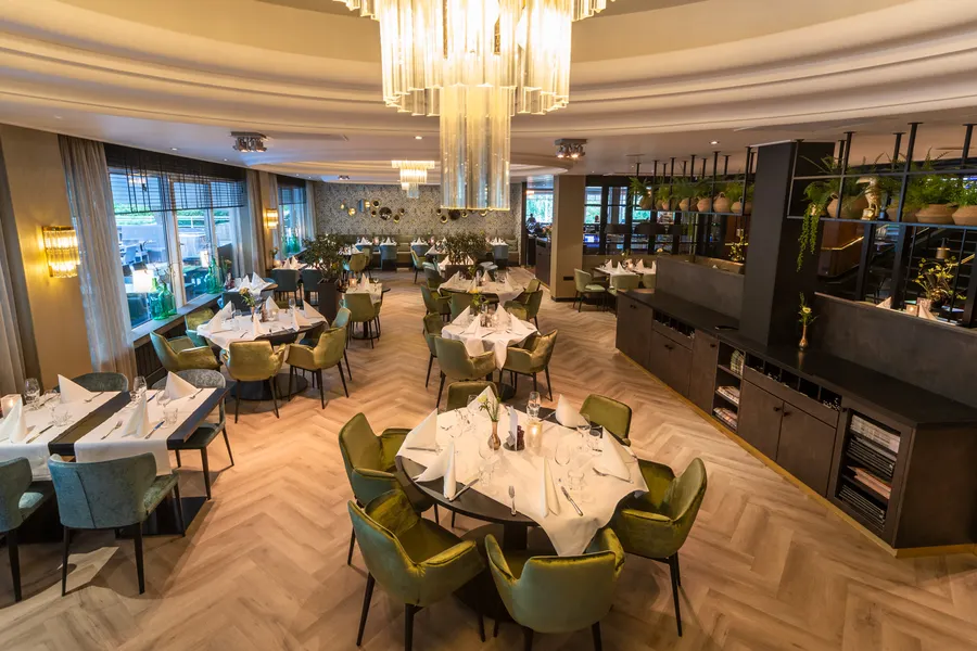 Overzicht van het restaurant, volledig in kerstsfeer gebracht met chique gedekte tafels.