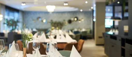 Atmosphärischer Überblick über das Restaurant de Witte, modern eingerichtet mit gedeckten Tischen für das inkludierte Drei-Gänge-Menü.